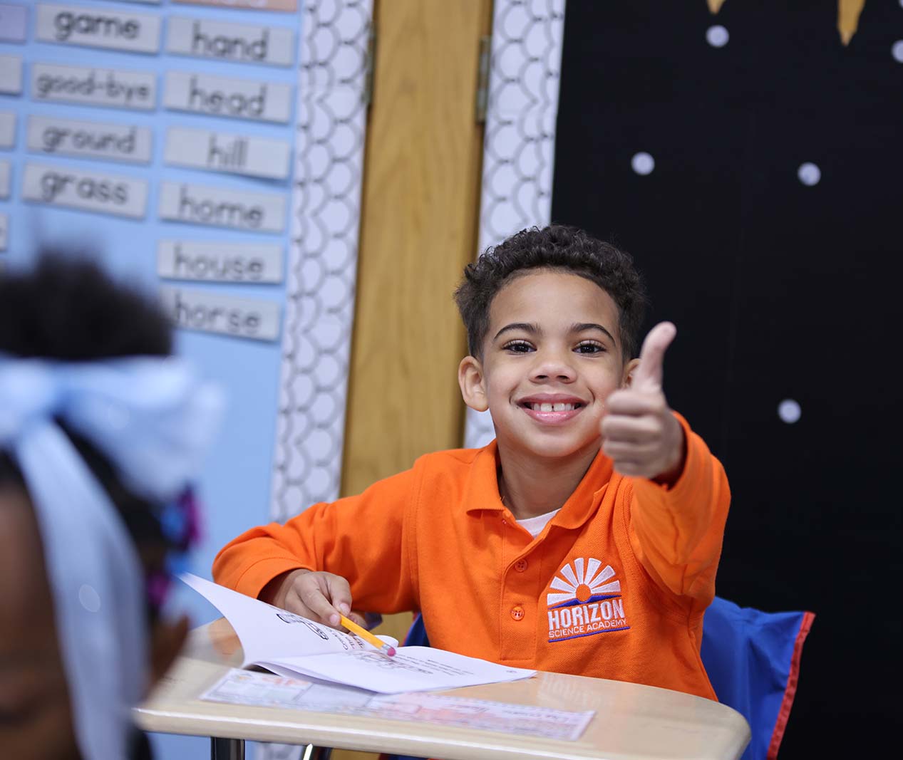 Student working on a notebook in a classroom.